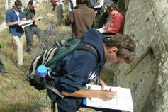 A group of students conducts geologic field studies.